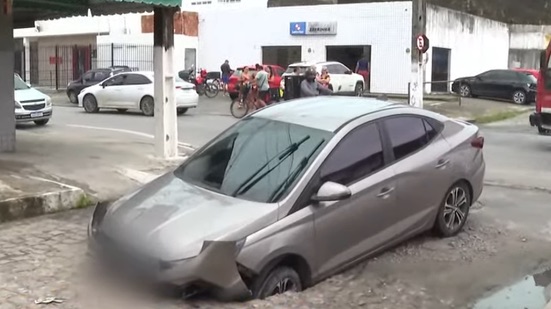 CARRO É ENGOLIDO POR CRATERA EM MEIO À CHUVA E ASSUSTA MORADORES EM MACEIÓ